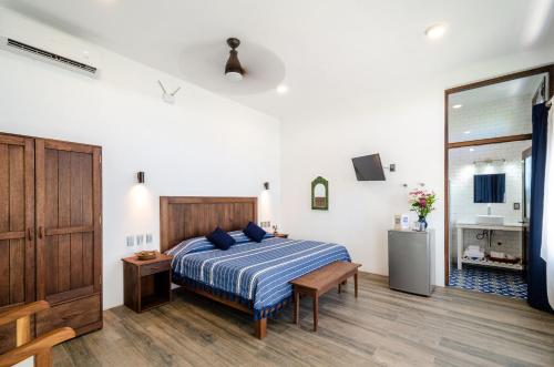 a bedroom with a bed with a blue comforter at Casa Kalmar in Zipolite