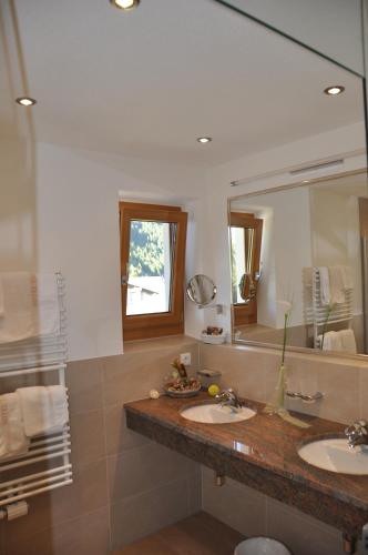 a bathroom with two sinks and a large mirror at Tauferberg in Umhausen