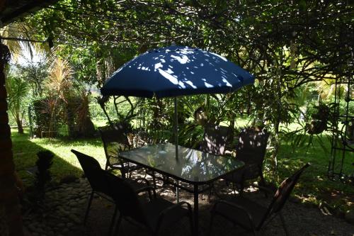 a table and chairs with a blue umbrella at The Mayan Grouper in Suchitoto