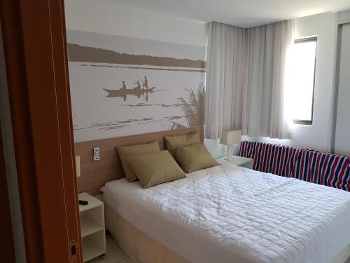 1 dormitorio con 1 cama y una pintura en la pared en Iloa Residence Resort - Barra de São Miguel, en Barra de São Miguel