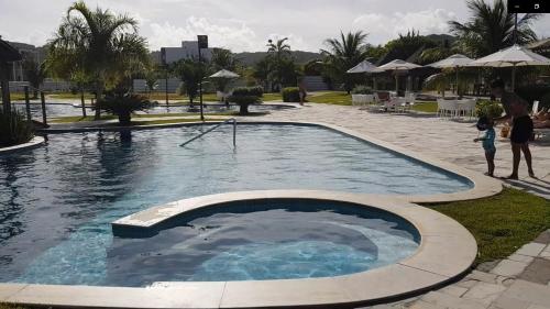 a swimming pool in a resort with people standing around it at Iloa Residence Resort - Barra de São Miguel in Barra de São Miguel