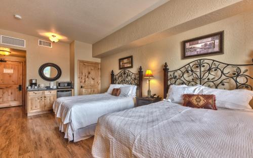 ein Hotelzimmer mit zwei Betten mit weißen Laken in der Unterkunft Steps to skiing, resort property, mountain views, shared hot tub, sauna, steam room 223 in Park City