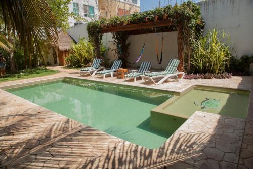 a swimming pool with chairs and a gazebo at Beautiful Private Villa for 16 PAX with garden, BBQ and pool, Playa del Carmen in Playa del Carmen