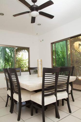 a dining room table and chairs with a ceiling fan at Beautiful Private Villa for 16 PAX with garden, BBQ and pool, Playa del Carmen in Playa del Carmen