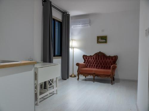 a living room with a red couch and a lamp at KINGS SQUARE Holiday Apartments in Polis Chrysochous