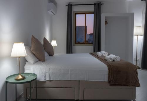a bedroom with a large white bed and a window at KINGS SQUARE Holiday Apartments in Polis Chrysochous