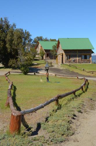 a log fence in front of a house at Complejo Don Cirilo in Villa Pehuenia