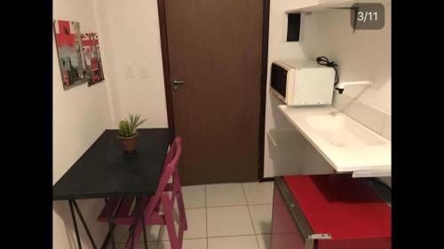 una pequeña cocina con mesa y microondas en Studio Piedade, en Recife