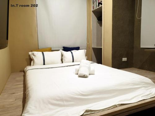a white bed with towels on top of it at In.T in Tainan