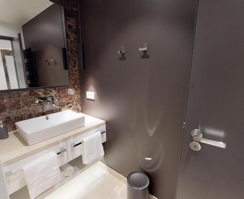 een badkamer met een wastafel, een toilet en een spiegel bij White Pearl Apartment 0.15 in Timmendorfer Strand
