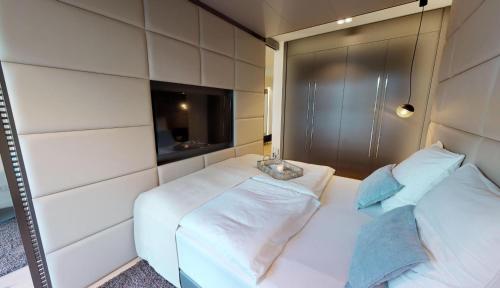 ティメンドルファー・シュトラントにあるWhite Pearl Apartment 0.15の白いベッド2台とテレビが備わる客室です。