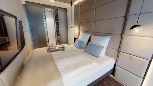 een kleine slaapkamer met een wit bed met blauwe kussens bij White Pearl Apartment 0.12 in Timmendorfer Strand