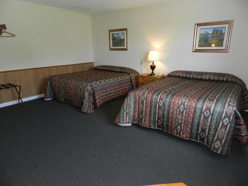 a hotel room with two beds and a lamp at C-Way Resort in Clayton