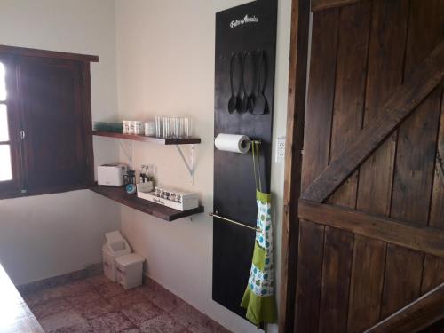 a room with a door and a kitchen with utensils at Entre Acequias in General Alvear