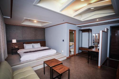 a bedroom with a bed and a desk and a couch at Hotel Noblesse in Seoul