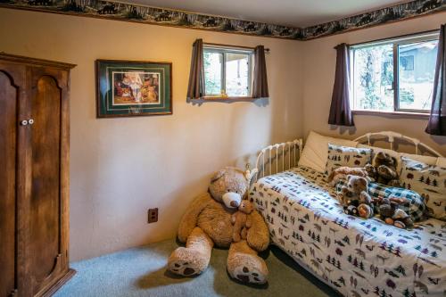 a teddy bear sitting on the floor in a bedroom at Yosemite Cub's Cabin in Yosemite West
