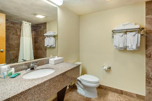 a bathroom with a sink and a toilet and a mirror at Atlantic Beach Hotel Newport in Middletown