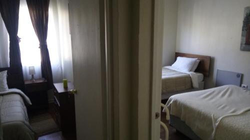 a hotel room with two beds and a window at Hostal Los Castaños in Viña del Mar