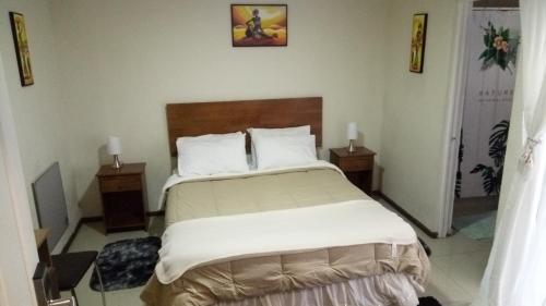 a bedroom with a large bed with two night stands at Hostal Los Castaños in Viña del Mar