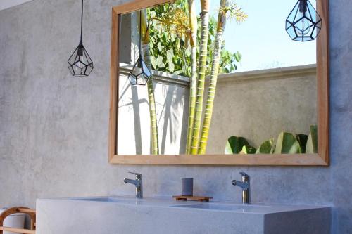 a bathroom with a sink and a mirror at The Inn Possible in Uluwatu