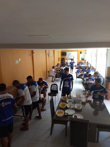 a group of children standing around a table with food at Pousada Pilotos in Itapipoca