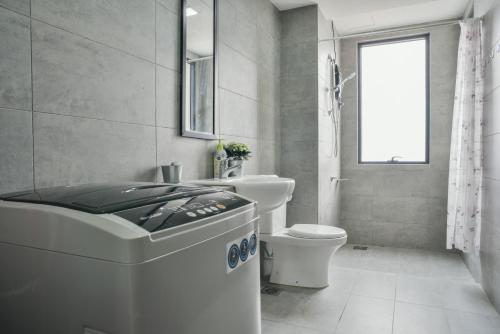 a bathroom with a tub and a toilet and a window at USJ One HomeStay @ Subang HomeStay in Subang Jaya