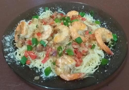a plate of food with shrimp and noodles at Soul Travellers Dagatan Guesthouse in Badian