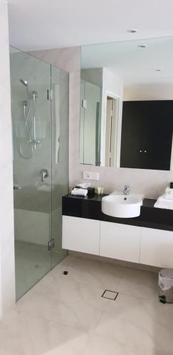 a bathroom with a glass shower and a sink at Hogans Motel in Wallan