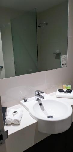 a bathroom with a white sink and a mirror at Hogans Motel in Wallan