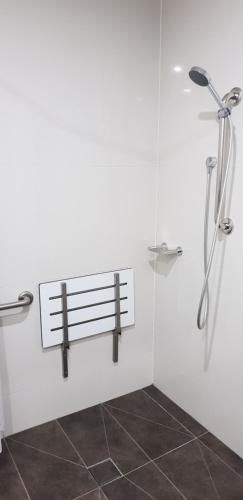 La salle de bains est pourvue d'une douche et d'un banc. dans l'établissement Hogans Motel, à Wallan