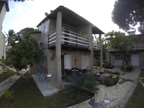 a house with a courtyard with a fire hydrant at Chalé 4, Maragogi, Condominio Village Galés in Maragogi
