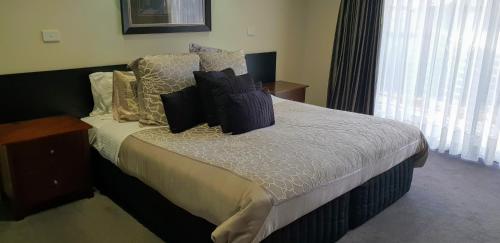 a bedroom with a bed with pillows on it at Hogans Motel in Wallan