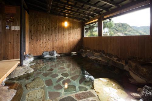 a room with a pool of water with rocks in it at Ishinoya Izunagaoka - TKP Hotels & Resorts in Izunokuni