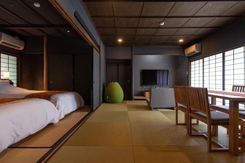 a bedroom with a bed and a table and chairs at Ishinoya Izunagaoka - TKP Hotels & Resorts in Izunokuni
