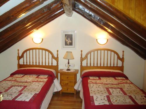 a attic bedroom with two beds and a lamp at Casa Duplex La Buhardilla in Torla-Ordesa