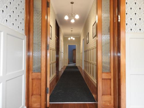 a hallway with wooden doors and a hallway with a black rug at Gardner Court Motel in Napier