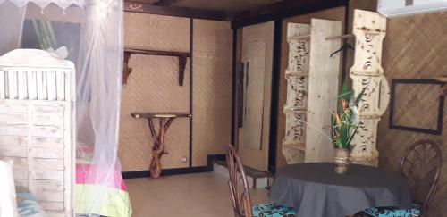 a dining room with a table and a crib at Haere Mai I Te Fare in Teavaro