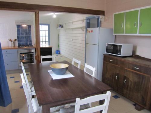 a kitchen with a wooden table with a bowl on it at Breakaway Cottage in Tumbarumba