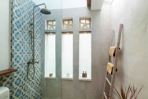 a bathroom with a shower with a glass door at Villa Coralita Gili Trawangan in Gili Trawangan