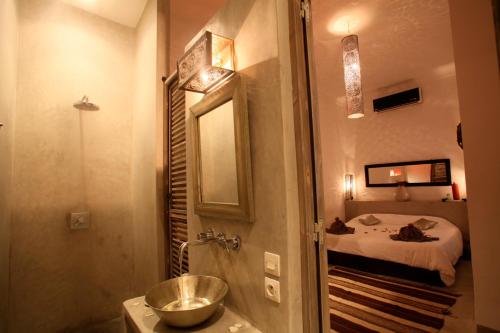 a bathroom with a sink and a mirror and a bed at Riad De Vinci & SPA in Marrakech