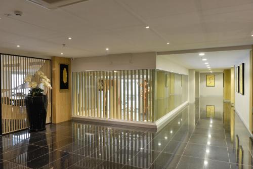 a hallway with a vase of flowers in a building at Le D'Tel Bangkok in Bangkok