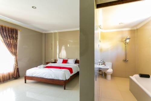 a bedroom with a bed and a sink and a tub at RedDoorz near Parangtritis Beach in Bantul