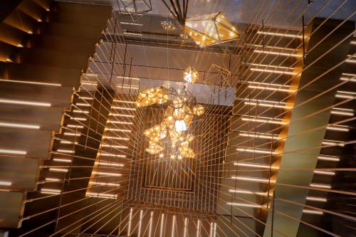a chandelier with lights on a wall at Pullman Huizhou Kaisa in Huizhou