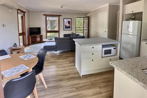 Una cocina y una sala de estar con mesa y sillas. en Peace Retreat Bright, en Bright