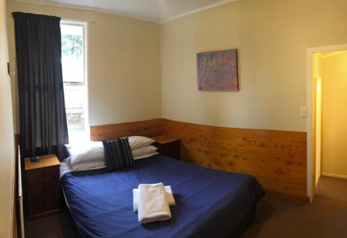 a bedroom with a blue bed and a window at Pukenui Lodge in National Park