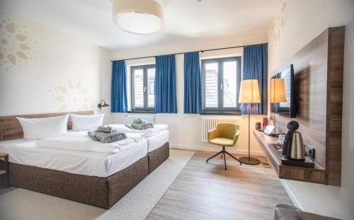 a hotel room with two beds and a desk at Spreewelten Hotel in Lübbenau