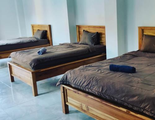2 camas con almohadas azules en un dormitorio en Medewi Beach Inn, en Pulukan