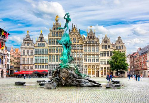 a statue in the middle of a city with buildings at Charming Suites Jan Zonder Vrees in Antwerp