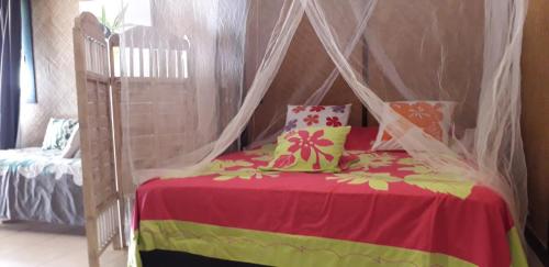 a bedroom with a bed with a canopy at Haere Mai I Te Fare in Teavaro
