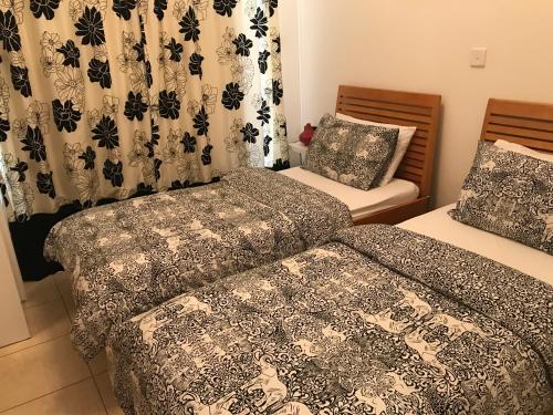 2 Betten in einem Zimmer mit Vorhängen in der Unterkunft Villa Kallista in Pissouri